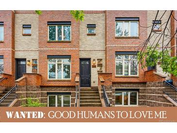 Charming brick townhome with a black door and well-manicured landscaping at 2319 Decatur St, Denver, CO 80211
