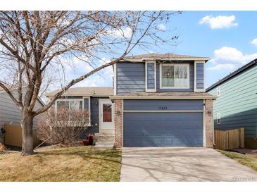 Charming two-story home with a blue exterior, brick accents, and a well-maintained front yard at 17623 Cornish Pl, Parker, CO 80134