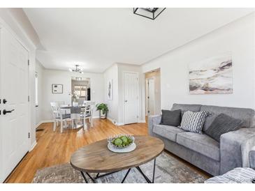 Bright living room with hardwood floors, modern decor, and seamless flow into the dining area at 3258 Niagara St, Denver, CO 80207