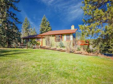 Charming single Gathering home featuring a green exterior, red trim, and a lush front lawn at 8473 Gray Fox Dr, Evergreen, CO 80439