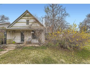 Cozy home exterior showcasing a quaint front porch, mature shrubs, and street view at 1824 S Logan St, Denver, CO 80210