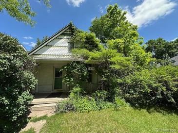 Charming home with decorative shingles and lush foliage surrounding the entrance at 1824 S Logan St, Denver, CO 80210