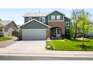 Charming two-story home with a well-manicured lawn, a gray exterior, and brick accent at 19716 Glendale Ln, Parker, CO 80134