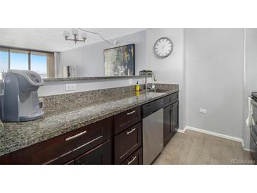 Well-lit kitchen features granite countertops, modern fixtures, and stainless steel dishwasher at 1020 15Th St # 9N, Denver, CO 80202