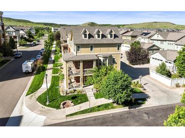 Beautiful multi-story home featuring brick accents, multiple balconies, landscaped yard, and inviting outdoor fire pit at 10241 Bellwether Ln, Lone Tree, CO 80124