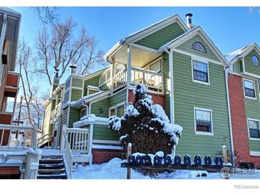 Green townhouse exterior featuring multiple stories, porches, and brick accents during the snowy winter at 3025 Broadway St # 17, Boulder, CO 80304