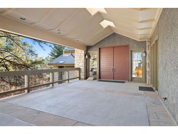 Inviting front entrance featuring a covered porch, stone accents, and double front doors at 108 Castle Pines N Dr, Castle Rock, CO 80108