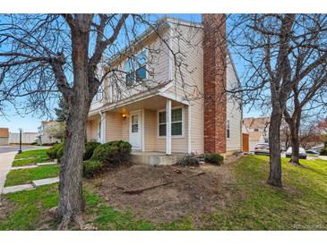 Charming townhouse exterior with well-maintained lawn, mature trees and brick chimney detail at 12133 Bannock Cir # D, Westminster, CO 80234