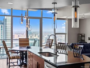 Bright kitchen featuring granite countertops, modern lighting, and expansive windows with city views at 891 14Th St # 3410, Denver, CO 80202