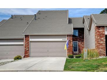 Charming home featuring a brick facade, a two-car garage, and a well-maintained front yard at 9403 Southern Hills Cir, Lone Tree, CO 80124