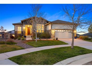 Beautiful home with stone accents, a two-car garage, and a cozy porch under a clear blue sky at 8505 S Tibet Ct, Aurora, CO 80016