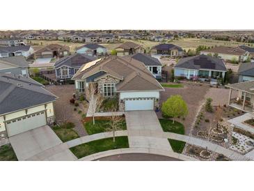 Stunning front exterior view, featuring a two-car garage, well-manicured landscaping, and a welcoming driveway at 8505 S Tibet Ct, Aurora, CO 80016