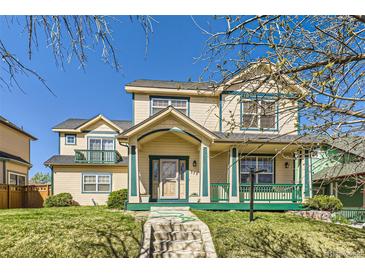 Charming two-story home with a covered porch and well-manicured lawn offers curb appeal at 375 Longspur Dr, Brighton, CO 80601
