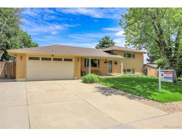 Charming brick home featuring a two-car garage, covered entryway, and well-manicured lawn at 960 S Arbutus St, Lakewood, CO 80228