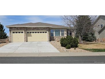 Charming single-story home boasting a stone facade, two-car garage, and well-maintained landscaping at 5480 Craftsman Dr, Parker, CO 80134