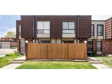 Townhome exterior with a privacy fence and lush lawn in front, providing a cozy and inviting curb appeal at 9453 W Utah Pl, Lakewood, CO 80232
