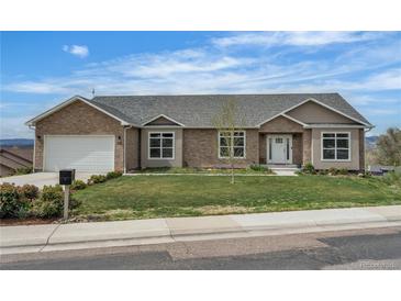 Charming brick home features a manicured lawn, a two-car garage, and lovely landscaping at 6839 Estes Dr, Arvada, CO 80004