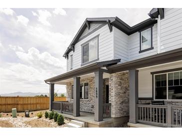 Charming two-story home with stone accents and a covered porch, offering curb appeal and outdoor living space at 5099 S Robb St, Littleton, CO 80127