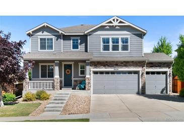 Charming two-story home with a well-manicured lawn, stone accents, and a three-car garage at 20529 E Brunswick Pl, Aurora, CO 80013