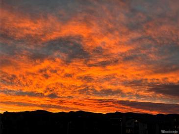 Vibrant sunset featuring orange and yellow clouds above dark silhouette of city skyline in Colorado at 8829 Animas River St, Littleton, CO 80125