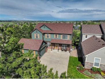 Charming two-story home with a well-maintained lawn and a classic brick-accented facade at 23427 Song Bird Hills Pl, Parker, CO 80138