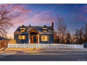 Inviting blue two-story home with a classic white picket fence and beautiful dusk sky backdrop at 285 E Dartmouth Ave, Englewood, CO 80113