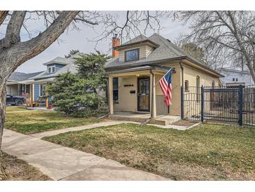 Charming single-story home featuring a cozy front porch, well-maintained lawn, and an American flag at 3064 S Cherokee St, Englewood, CO 80110