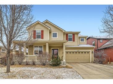 Charming two-story home featuring red shutters, a covered front porch, and a two-car attached garage at 1157 Mircos St, Erie, CO 80516