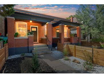 Charming brick duplex showcasing covered front porches and landscaped front yards with decorative white rock at 3329 N High St, Denver, CO 80205