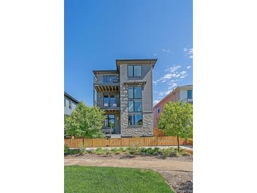 Modern home with stone accents, balconies, and a well-maintained front yard at 6047 N Nepal Ct, Aurora, CO 80019