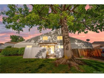 Inviting two-story townhome featuring lush green lawn and mature trees, capturing idyllic curb appeal at 8738 Chase Dr # 133, Arvada, CO 80003