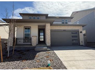 Beautiful two-story home with stone accents, a covered porch and a gray two-car garage at 8840 Whiteclover St, Littleton, CO 80125
