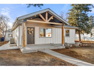 Inviting home featuring a stylish front porch with modern wooden support beams and neutral color palette at 3287 S Humboldt St, Englewood, CO 80113