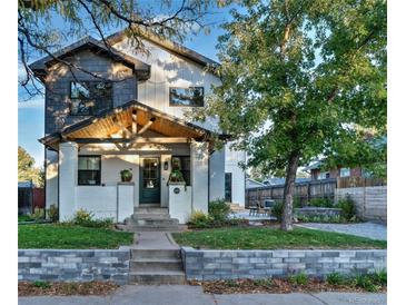 Charming two-story home with beautiful brick and siding, a covered front porch, and landscaped front yard at 2182 S Ogden St, Denver, CO 80210
