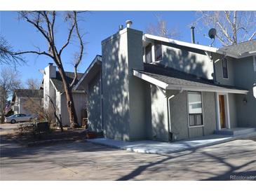 Charming home featuring a prominent chimney, gray exterior, and mature trees in a residential neighborhood at 9551 E Chenango Ave, Greenwood Village, CO 80111