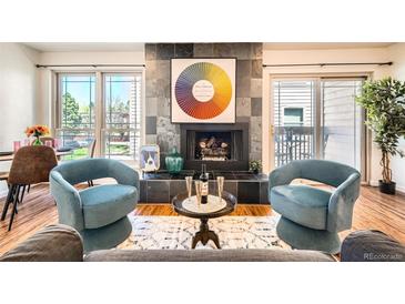 Inviting living room featuring a striking fireplace, modern furnishings, and plenty of natural light at 701 Harlan St # E59, Lakewood, CO 80214