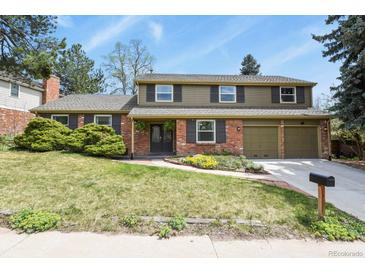 Charming two-story home with brick and siding exterior, a well-manicured lawn, and an attached two-car garage at 7376 S Jackson St, Centennial, CO 80122