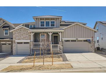 Charming two-story home with stone accents, a covered porch, and a three-car garage at 605 Twilight St, Erie, CO 80516