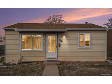 Charming single-story home featuring a quaint front door and neutral-colored siding with a serene sky at dusk at 7971 Olive St, Commerce City, CO 80022