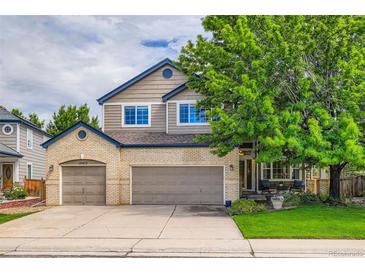 Charming two-story home with a three-car garage, landscaped yard, and welcoming front porch at 10472 Longleaf Dr, Parker, CO 80134
