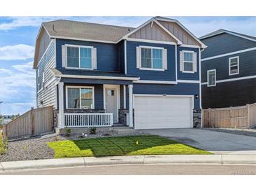 Charming two-story home with a covered porch, attached garage, and blue siding at 18350 Prince Hill Cir, Parker, CO 80134