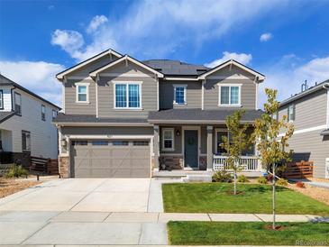 Beautiful two-story home with a manicured lawn, covered porch, and two-car garage at 821 Boulder Peak Ave, Erie, CO 80516