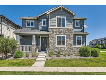 Charming two-story home with stone accents, landscaped front yard and covered entry at 11902 Norfolk Ct, Commerce City, CO 80022