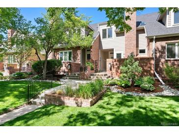 Charming two-story home featuring a manicured front lawn and attractive brick facade at 443 Garfield St, Denver, CO 80206