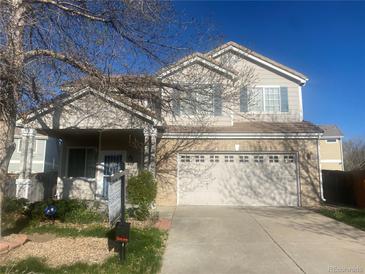 Two-story home with a two-car garage and a well-maintained front yard at 407 Ivory Cir, Aurora, CO 80011