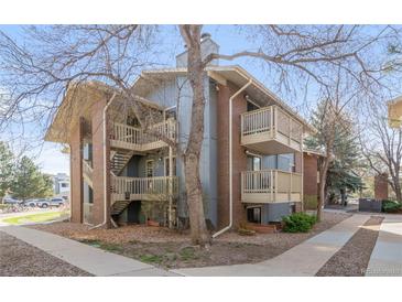 Apartment building featuring stairwells leading to private balconies, brick facade, and mature trees providing shade at 2800 Kalmia Ave # C101, Boulder, CO 80301