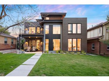 Modern home featuring a well-manicured lawn, large windows, and a second-story balcony at 2838 Tennyson St, Denver, CO 80212