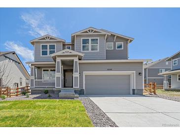 Charming two-story home with a well-maintained lawn and a two-car garage under a sunny sky at 4880 River Landing Ave, Firestone, CO 80504
