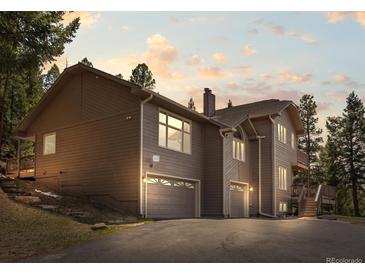 Charming two-story home featuring an attached two-car garage and a separate single car garage at 8724 Armadillo Trl, Evergreen, CO 80439