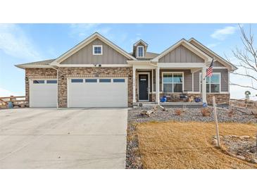 Two-story house with gray siding, stone accents, and a two-car garage at 15740 Spruce St, Thornton, CO 80602